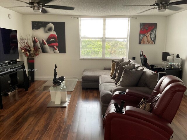 living room with ceiling fan, dark hardwood / wood-style floors, and a textured ceiling