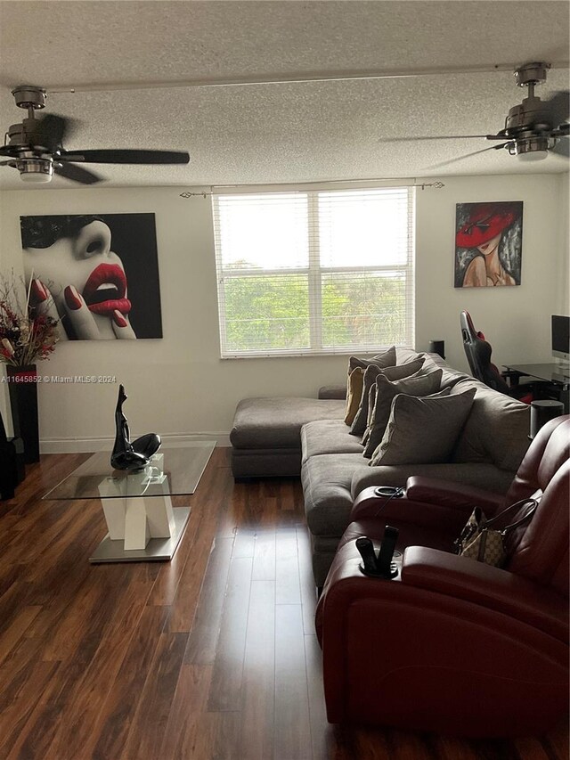 living room featuring ceiling fan, a textured ceiling, and hardwood / wood-style floors