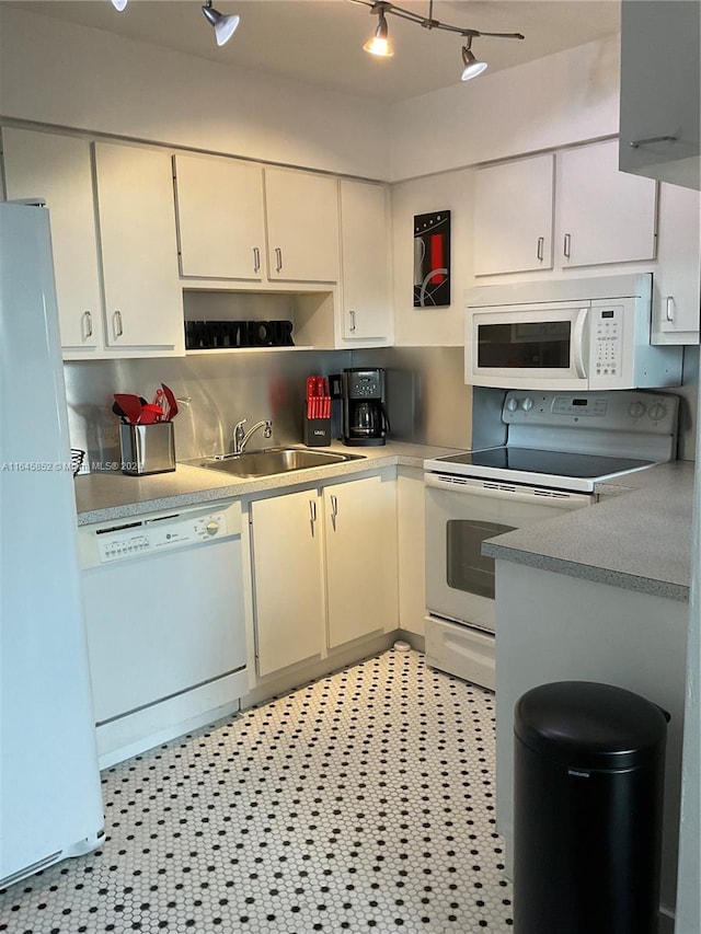 kitchen featuring sink, track lighting, white appliances, and light tile patterned floors