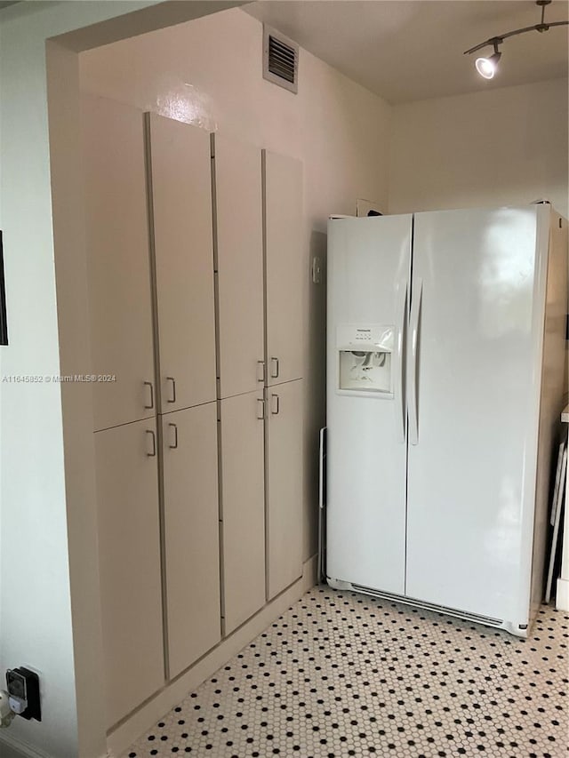 kitchen with white fridge with ice dispenser and light tile patterned floors