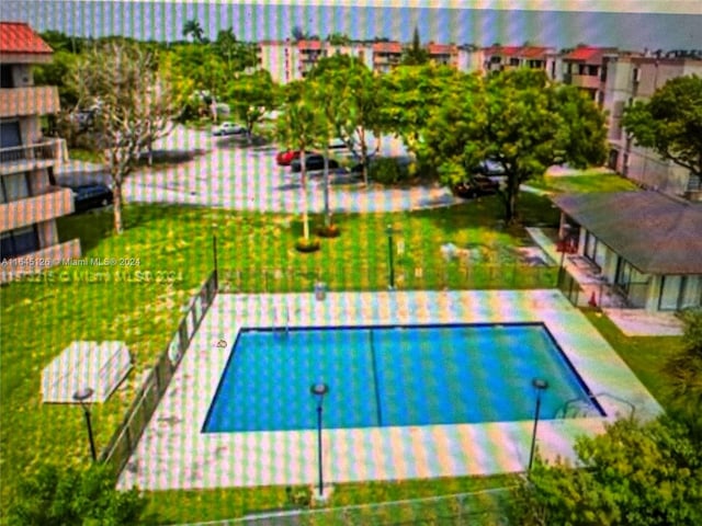 view of swimming pool with a lawn