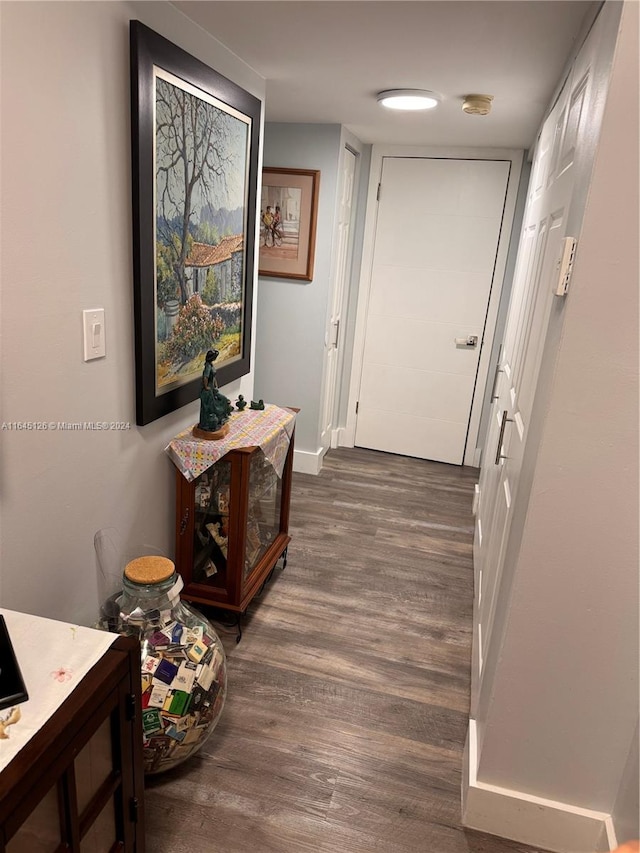 hall featuring dark wood-style floors and baseboards