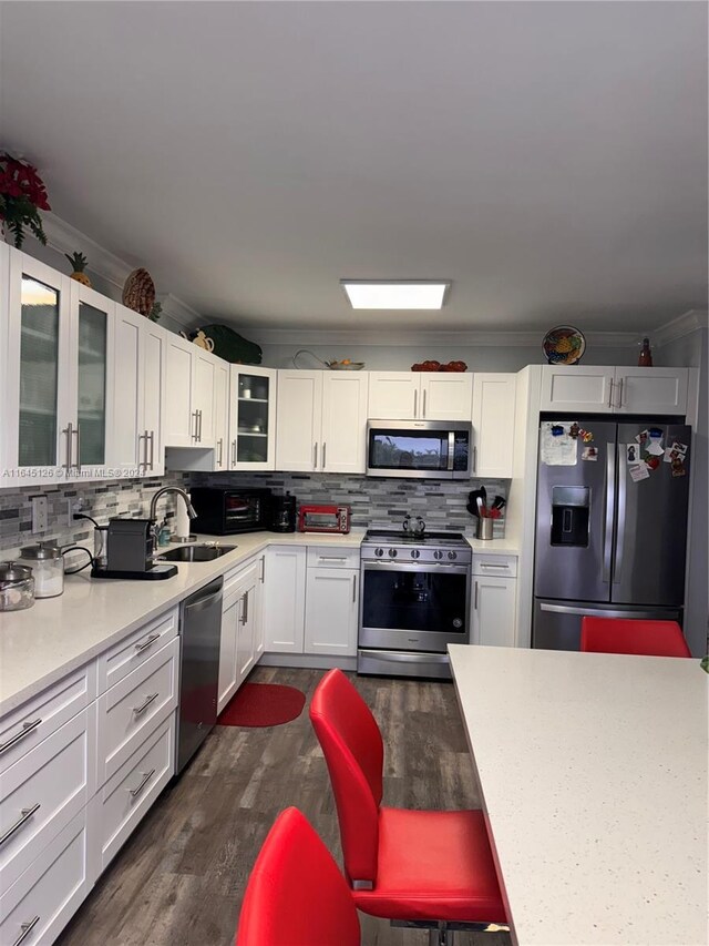 kitchen featuring stainless steel appliances, dark wood-type flooring, and decorative backsplash