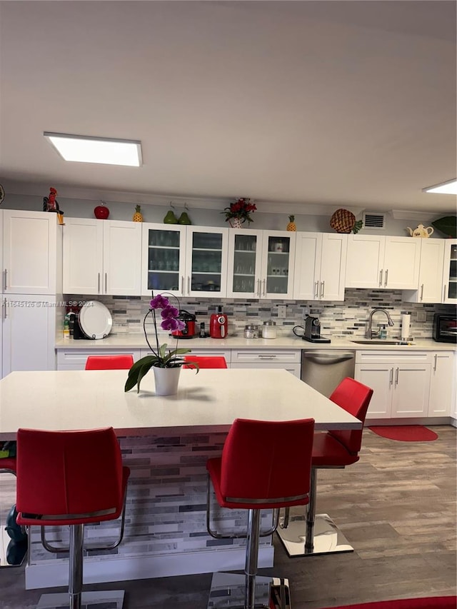 kitchen with dishwasher, sink, decorative backsplash, and white cabinets