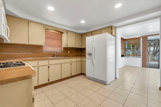 4296 E 9th Ln, Hialeah, FL 33013 - kitchen featuring white fridge with ice dispenser, cream cabinets, recessed lighting, and light countertops