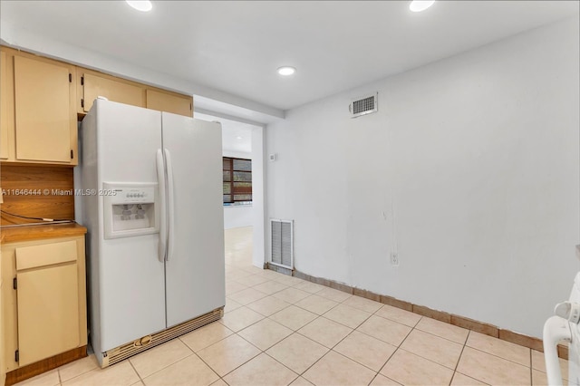 4296 E 9th Ln, Hialeah, FL 33013 - kitchen with white refrigerator with ice dispenser, recessed lighting, light tile patterned floors, and cream cabinetry
