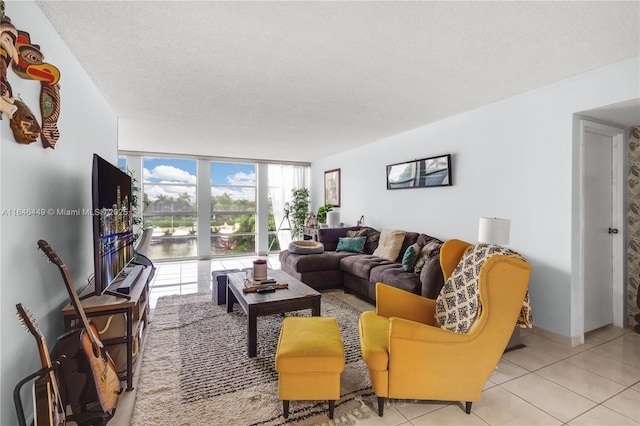 living room with expansive windows, light tile patterned floors, and a textured ceiling