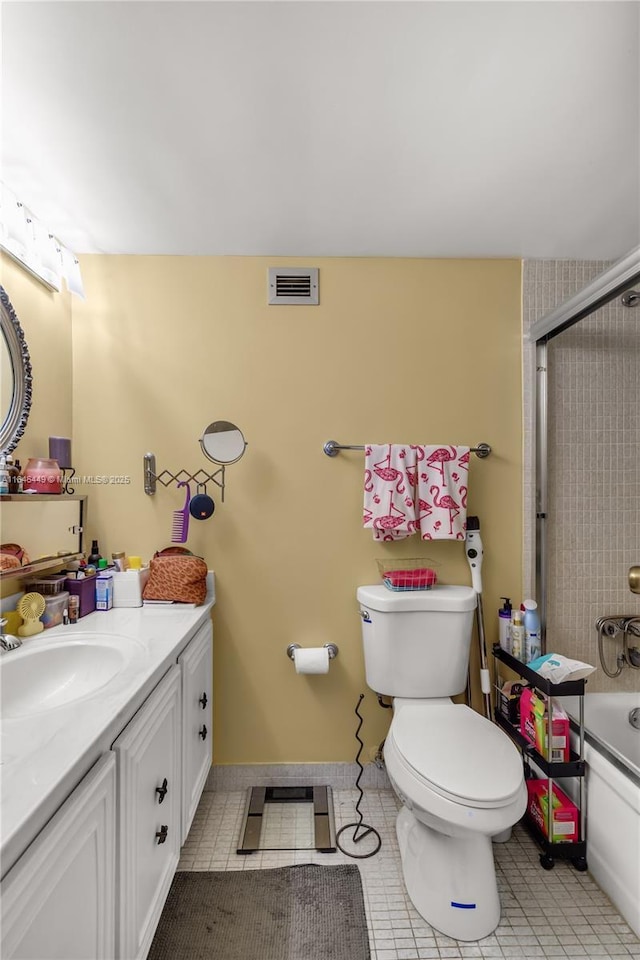 full bathroom featuring toilet, vanity, tile patterned floors, and enclosed tub / shower combo