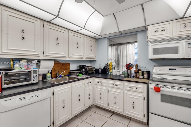 kitchen with sink, white cabinets, light tile patterned flooring, and white appliances