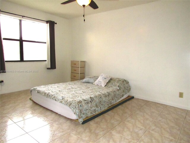 bedroom with ceiling fan and light tile patterned floors