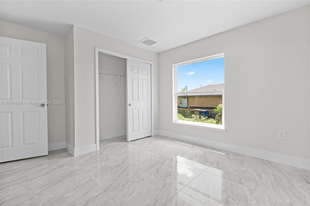 unfurnished bedroom featuring a closet and light tile patterned flooring