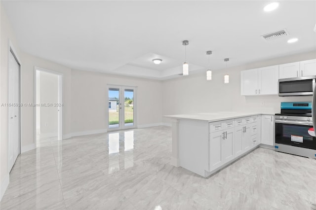 kitchen featuring light tile patterned floors, appliances with stainless steel finishes, pendant lighting, and white cabinetry