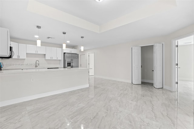 kitchen featuring hanging light fixtures, white cabinetry, appliances with stainless steel finishes, sink, and light tile patterned flooring