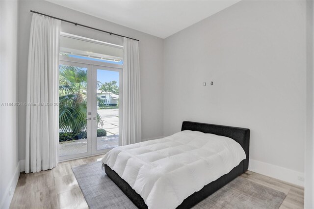 bedroom featuring light wood-type flooring, access to outside, and french doors