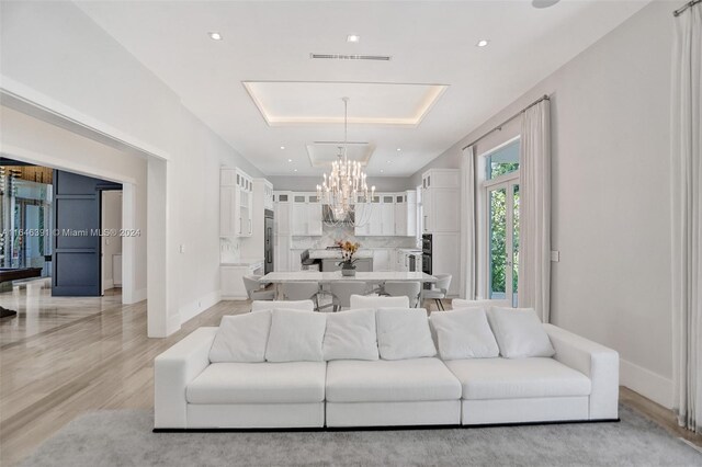 living room featuring light wood-type flooring and an inviting chandelier