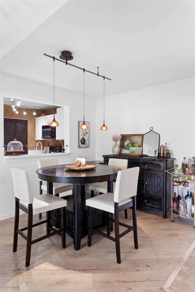 dining room featuring rail lighting and light wood-type flooring