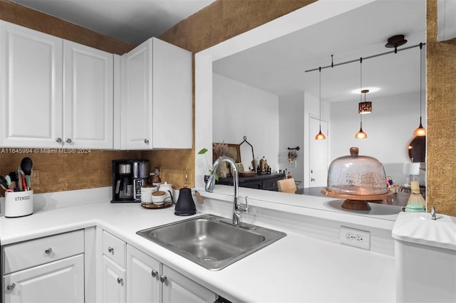 kitchen featuring white cabinets, pendant lighting, and sink