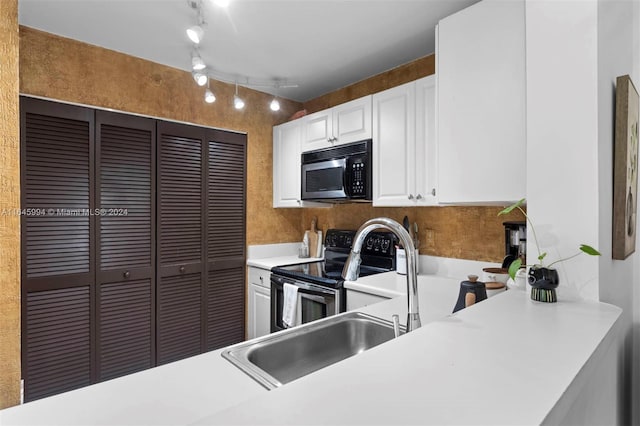 kitchen featuring appliances with stainless steel finishes, white cabinetry, and sink