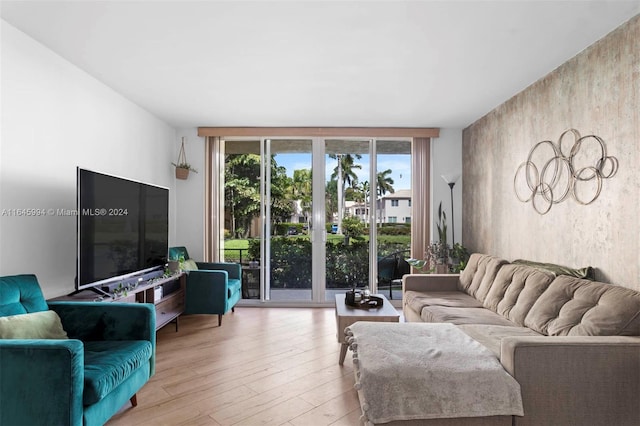 living room with floor to ceiling windows, light hardwood / wood-style floors, and french doors