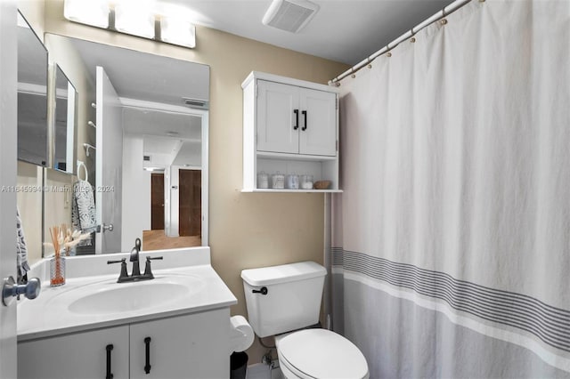 bathroom featuring a shower with shower curtain, toilet, and vanity