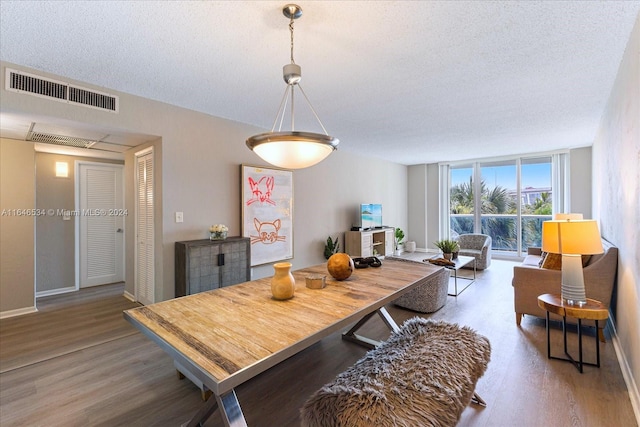 dining space featuring a textured ceiling and hardwood / wood-style floors