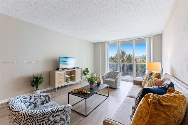 living room with a textured ceiling, light hardwood / wood-style floors, and floor to ceiling windows