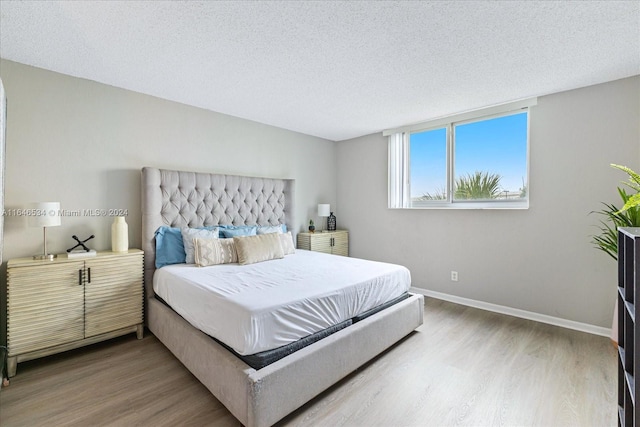 bedroom featuring a textured ceiling and light hardwood / wood-style floors