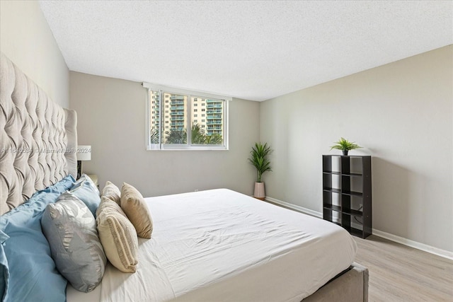 bedroom featuring light wood-type flooring and a textured ceiling