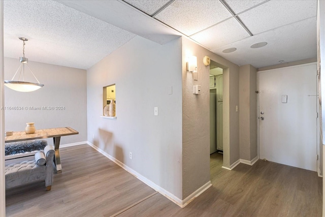 hall featuring hardwood / wood-style flooring and a drop ceiling