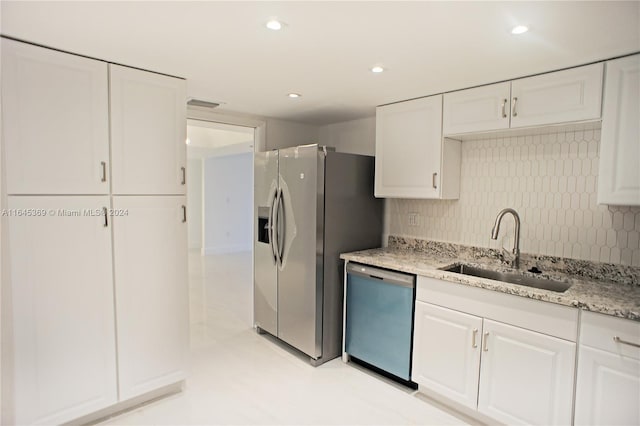 kitchen with backsplash, sink, appliances with stainless steel finishes, and white cabinetry