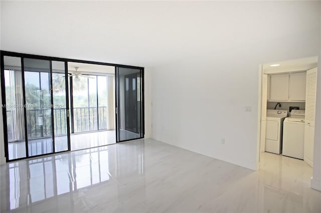 spare room with washer and clothes dryer, expansive windows, and ceiling fan