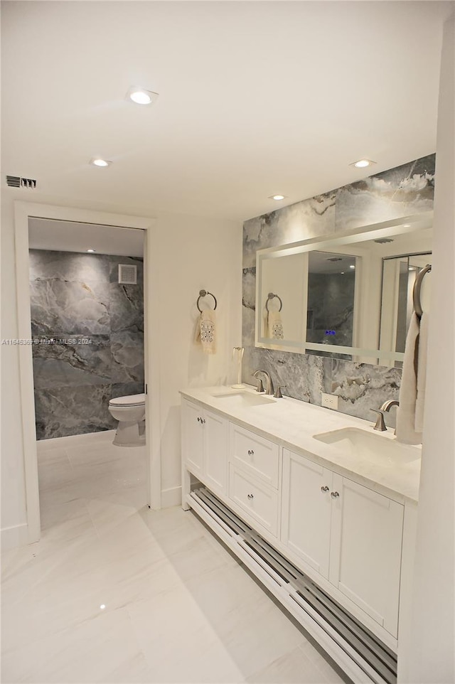 bathroom with tile walls, toilet, and vanity