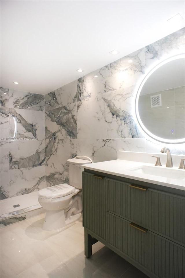 bathroom with tile walls, toilet, a shower, and vanity