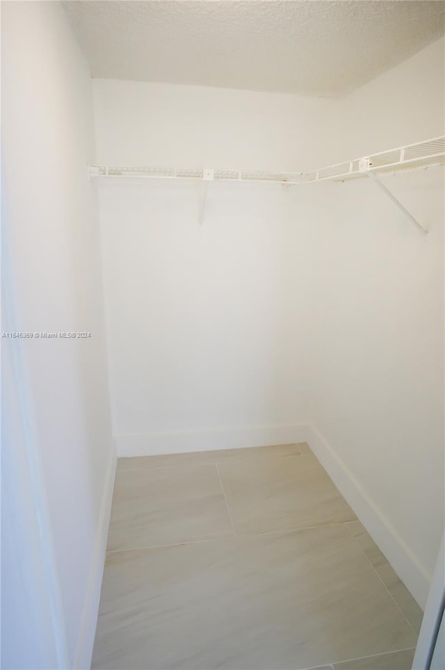 walk in closet with tile patterned flooring