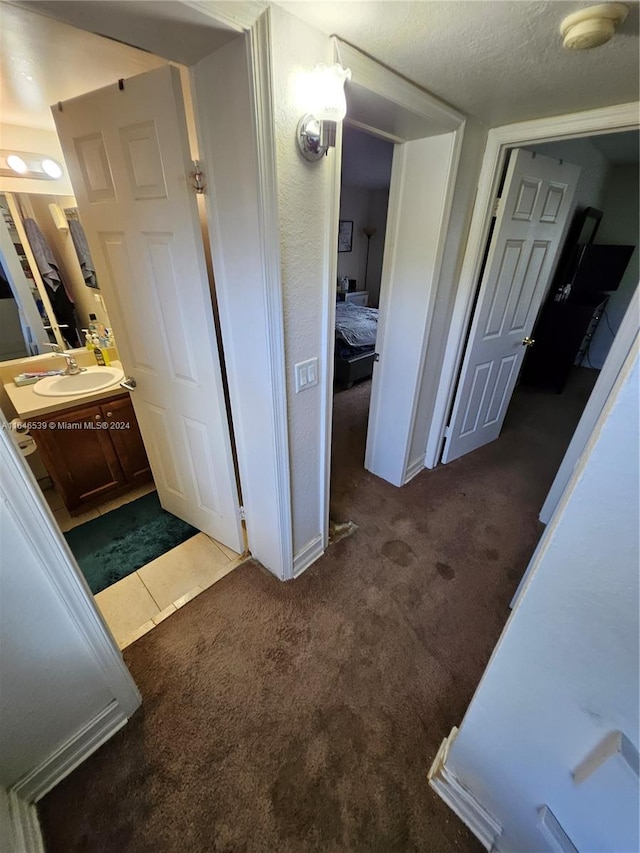 bathroom with a textured ceiling, vanity, and tile patterned floors