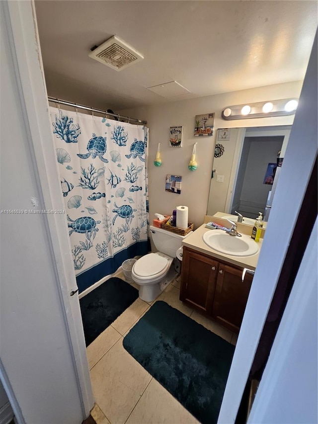 bathroom with tile patterned floors, toilet, walk in shower, and vanity