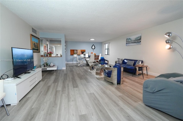 living room with light hardwood / wood-style floors and a textured ceiling