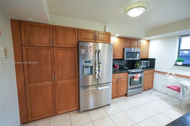 kitchen featuring light tile patterned floors, stainless steel appliances, and tasteful backsplash