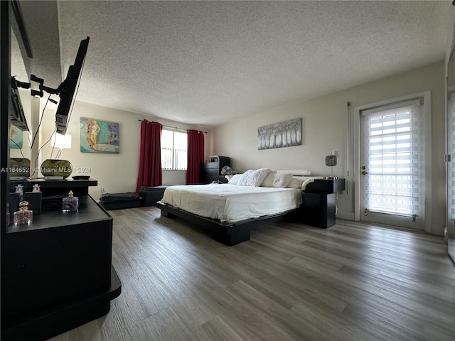 bedroom featuring a textured ceiling and hardwood / wood-style flooring