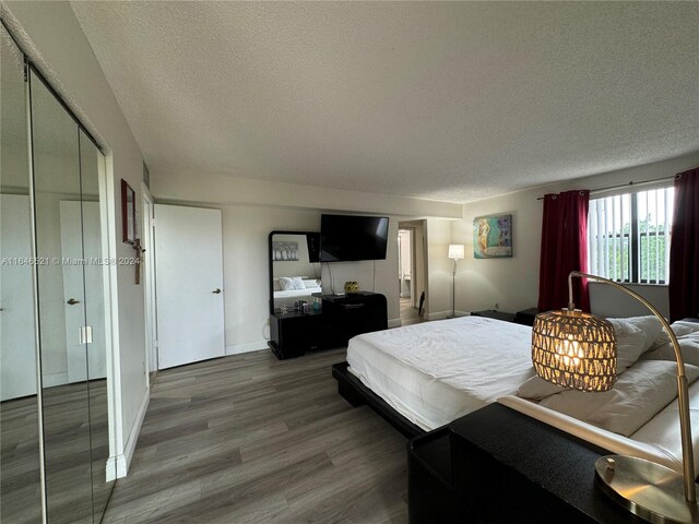 bedroom featuring wood-type flooring and a textured ceiling