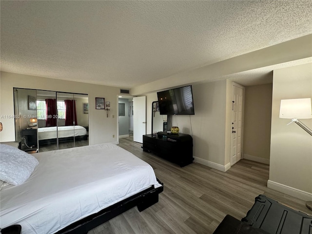 bedroom featuring a textured ceiling and hardwood / wood-style floors