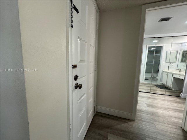 corridor featuring a barn door and hardwood / wood-style flooring