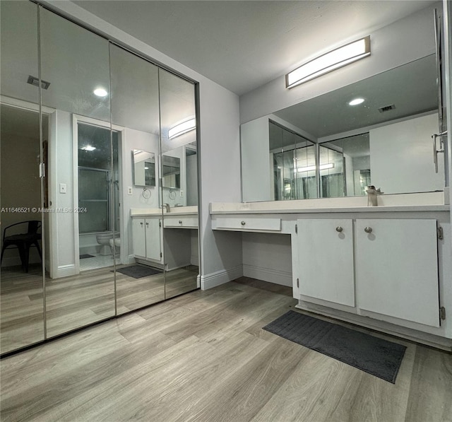 bathroom with vanity, toilet, and hardwood / wood-style flooring