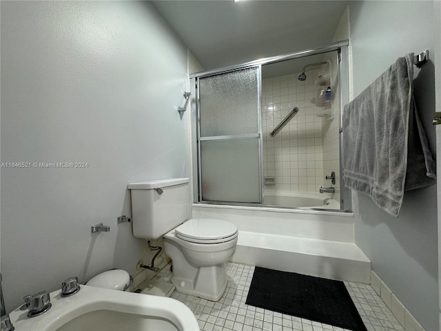 bathroom featuring combined bath / shower with glass door, toilet, and tile patterned floors