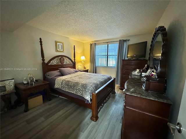 bedroom featuring a textured ceiling and dark hardwood / wood-style flooring