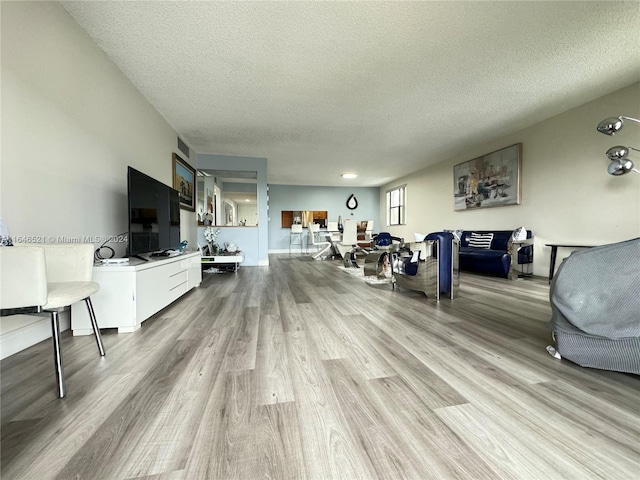 living room featuring a textured ceiling and light wood-type flooring