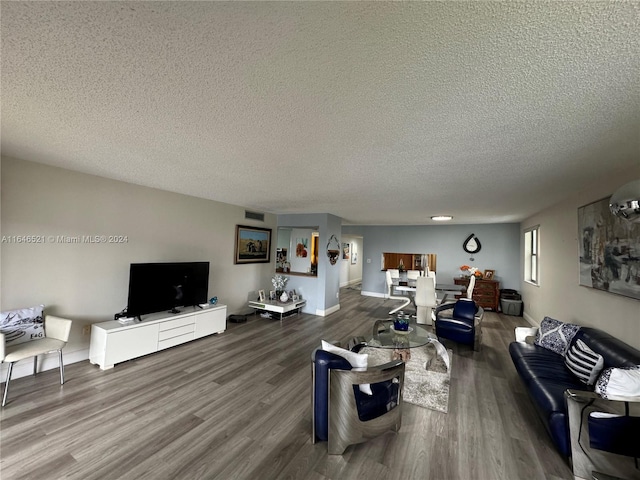 living room with a textured ceiling and hardwood / wood-style floors