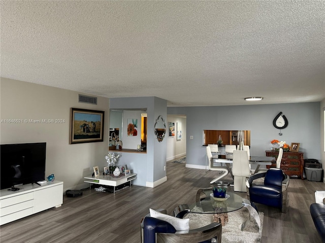 living room featuring a textured ceiling and dark hardwood / wood-style flooring