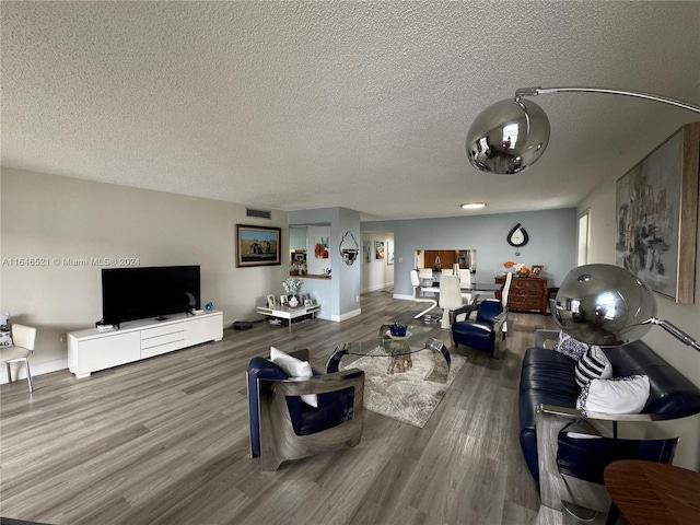 living room with a textured ceiling and hardwood / wood-style floors