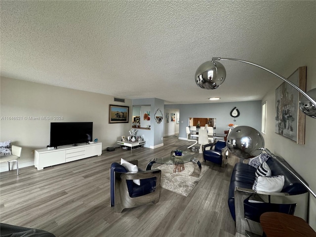 living room featuring wood-type flooring and a textured ceiling